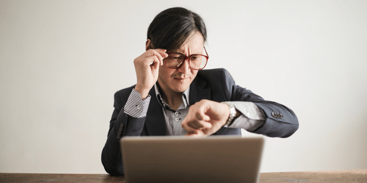 Man looking worriedly at his watch