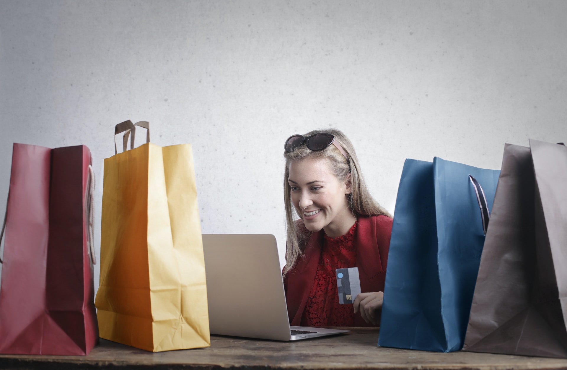 Zdjęcie uśmiechniętej kobiety wśród toreb z zakupami