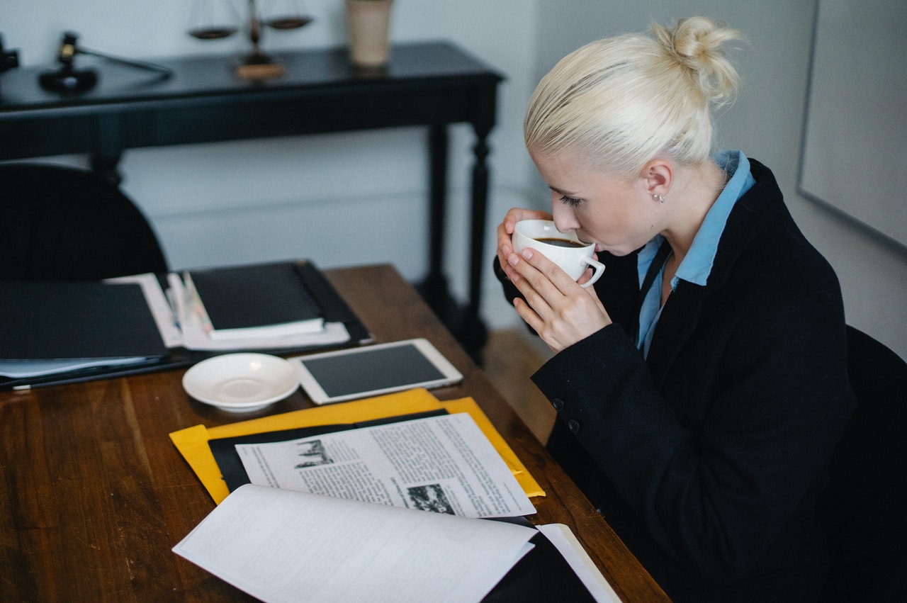 A lawyer drinking coffee while she looks at some documents