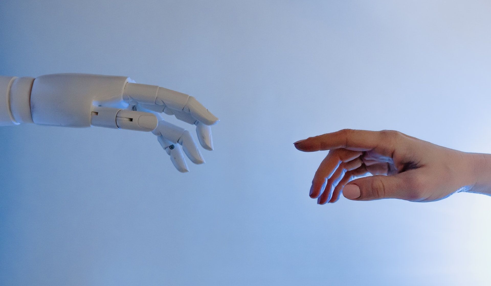 Zdjęcie ręki robota i człowieka, które za chwilę się zetkną