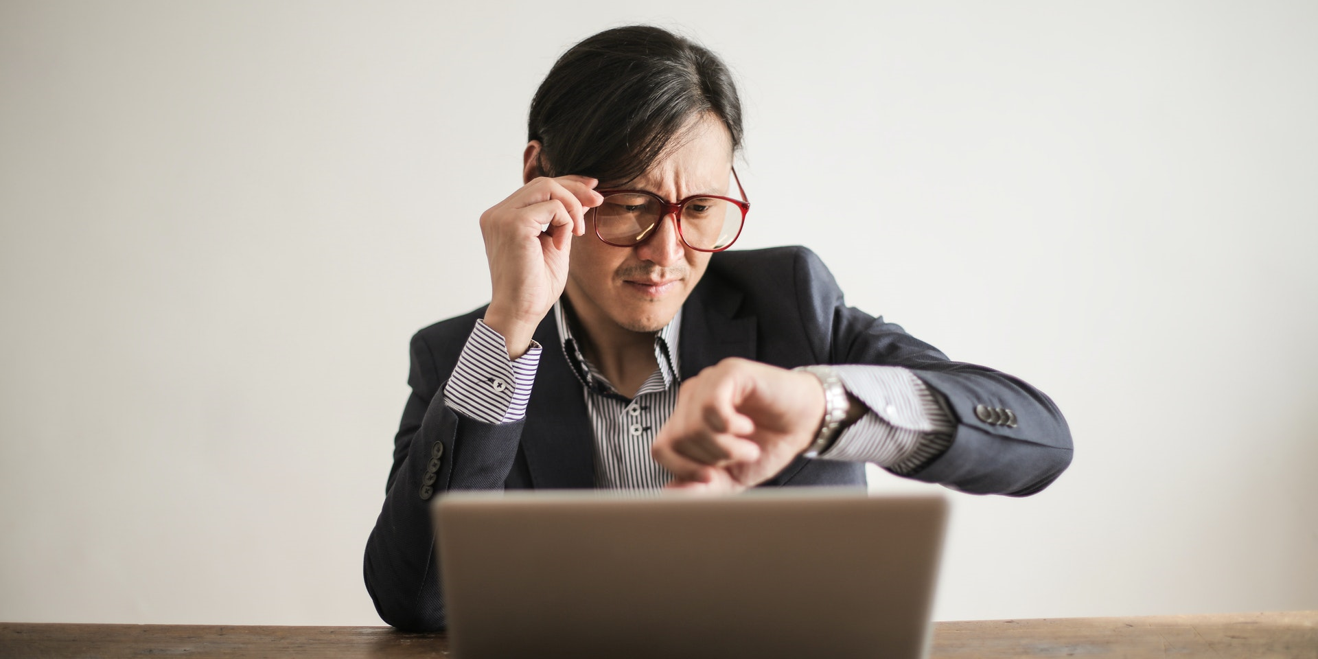 Businessman looking at his watch with a worried expression